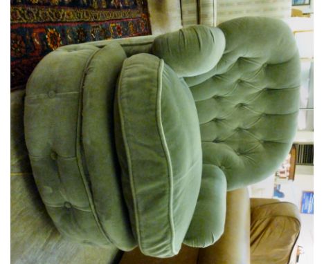 A modern armchair, part button upholstered in green dralon, raised on casters       CA