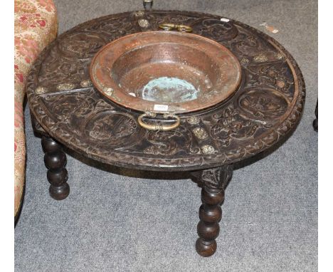 A 19th century carved oak Spanish style warming brazier table, the table carved with portrait busts of dragons around a centr