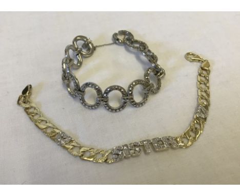 A gold plated silver bracelet with the word SISTER and 2 heart shaped sections. Together with a white metal bracelet with cir