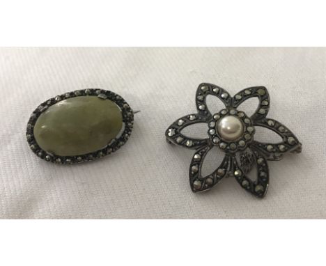 2 vintage silver brooches. One with an open flower design set with marcasite and a central faux pearl.  The other is an oval 