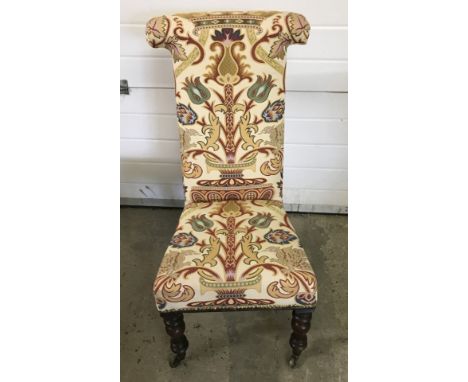 A Victorian hall chair with turned front legs and T shaped high back. With brass castors and bold print upholstery. 