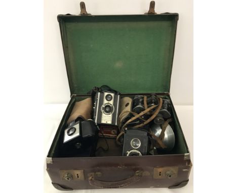 A collection of vintage cameras, accessories and binoculars in a small vintage suitcase. To include Kodak, Comet and Ensign f