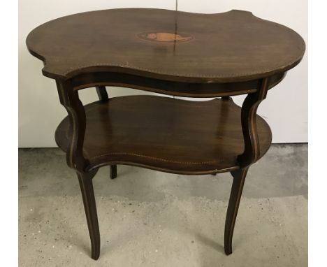 A decorative Victorian occasional table with shaped top and under shelf. Inlaid detail with shell decoration to top. Approx. 