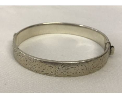 Hallmarked silver hinged bangle with decorative engraving.  Weight approx 16.1g.