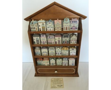 24 ceramic spice cannisters by Lenox. Complete with wooden rack. Cannisters in shape of miniature houses. With certificate. 