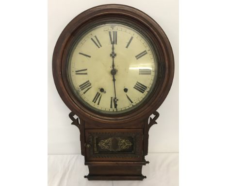 A vintage wooden cased wall hanging clock. Complete with key and pendulum. Approx. 70cm x 42cm.