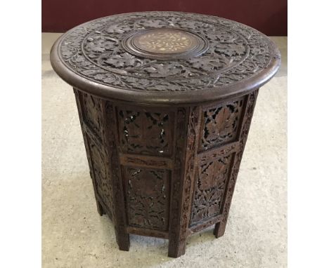 A vintage carved occasional table with octagonal shaped base and inlaid detail to top. Circular top with floral and leaf carv