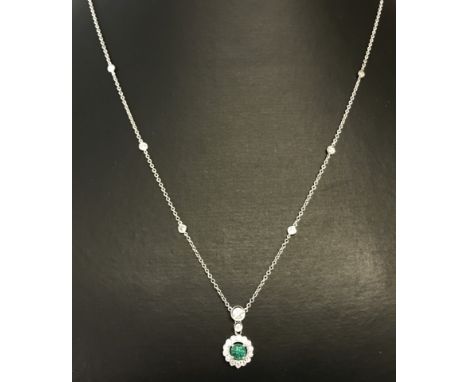 An 18ct white gold diamond and emerald necklace. Chain set with 6 diamonds. Necklace bale set with 2 diamonds, drop pendants 