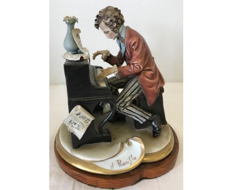 A Capodimonte figurine of a gentleman playing the piano. One finger a/f. 