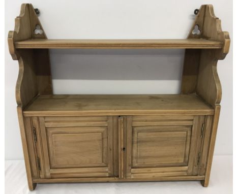 A vintage light oak wall hanging shelf with 2 door cupboard. Trefoil design to top. Approx. 61cm wide x 60cm tall.