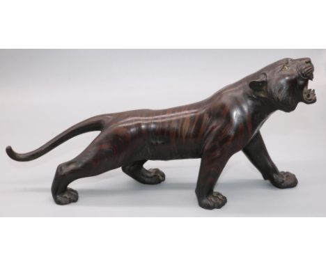 Japanese Meiji period patinated bronze model of a prowling tiger, with glass eyes and open mouth, seal mark in relief, L34cm 