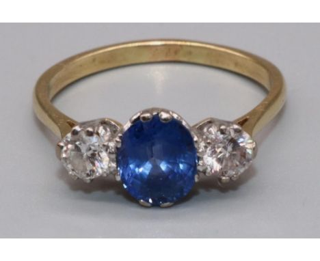 18ct yellow gold sapphire and diamond three stone ring, the central oval cut sapphire flanked by two round cut diamonds, in c