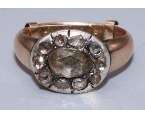 C18th yellow and white metal cluster ring, the large central old cut diamond surrounded by a halo of ten smaller diamonds in 