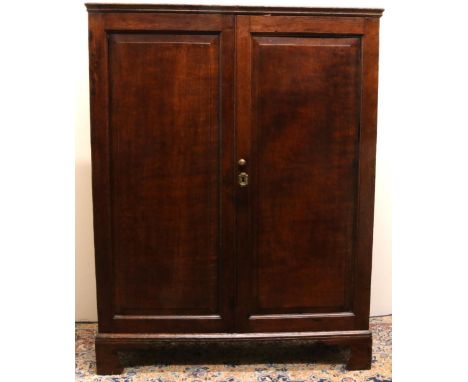 Early C19th oak Housekeepers cupboard, with moulded top above two fielded panel doors revealing two banks of six graduated dr
