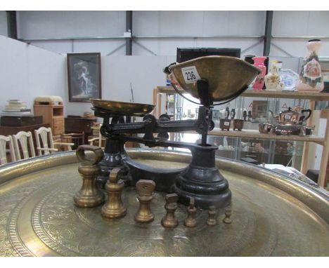A set of kitchen scales with brass pans and brass weights