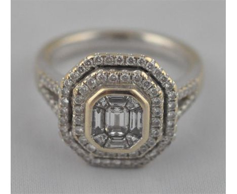 An 18ct. white gold and diamond set ring, having emerald cut mounting set nine stones to raised centre surrounded two bands o