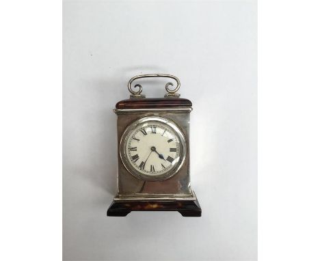 A late Victorian silver and tortoise shell miniature timepiece, with caddy top and scrolling handle, raised upon bracket feet