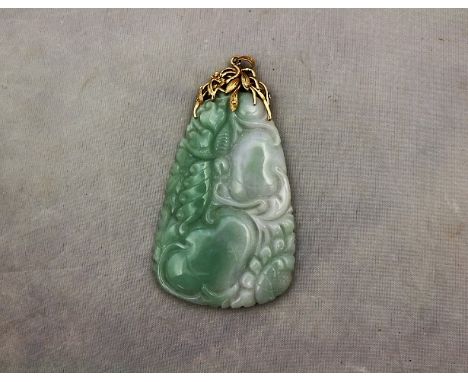 &nbsp;A large Chinese 14ct. yellow gold and mottled green jade pendant, of adze form, engraved with foliage, within openwork 
