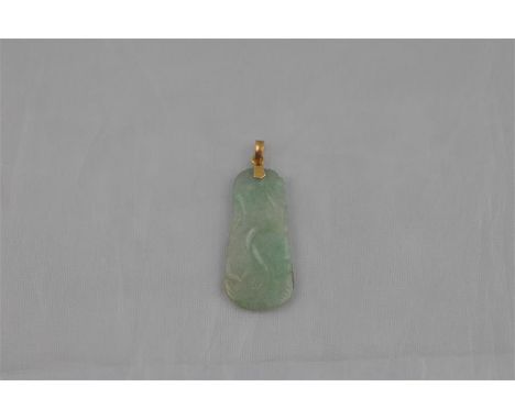 A mottled green jade axe form pendant, carved with a stylised fish among waves to both sides, with yellow metal mount and bai