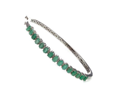 WHITE TOPAZ AND EMERALD BANGLE, set with oval emeralds totalling approximately 3.22 carats, interspaced by round white topaz 