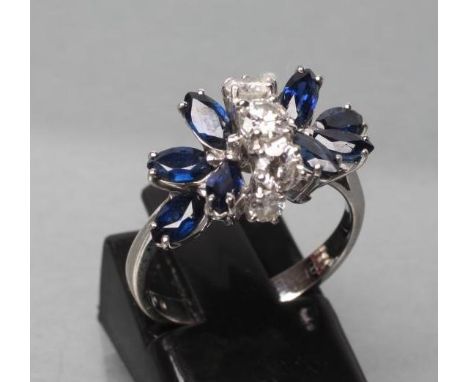 A SAPPHIRE AND DIAMOND DRESS RING, the two marquise set sapphire "flowers" interspersed with a band of five graduated brillia