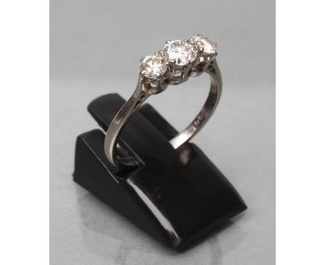 A THREE STONE DIAMOND RING, the central old cut stone of approximately 0.30cts, flanked by two similar smaller stones each of
