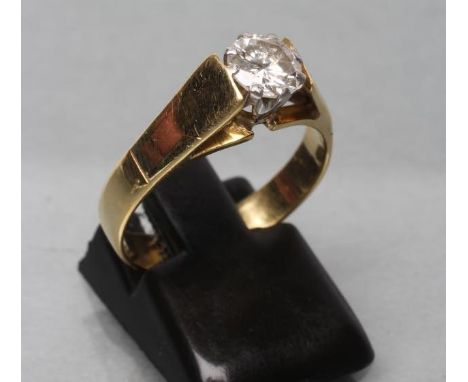 A SOLITAIRE DIAMOND RING, the brilliant cut stone of approximately 0.6cts claw set to a wide shank, stamped 18ct, size O (Est