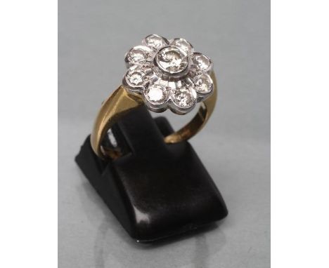 A DIAMOND CLUSTER RING, the central round brilliant of approximately 0.12cts to a frilled border and further open collet set 