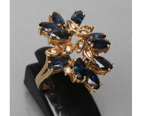 A SAPPHIRE AND DIAMOND COCKTAIL RING, set with ten marquise cut sapphires and nine single channel set small diamonds to open 