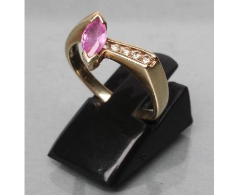 A PINK SAPPHIRE AND DIAMOND ANGULAR CROSSOVER RING, the marquise cut sapphire beside four graduated small channel set diamond