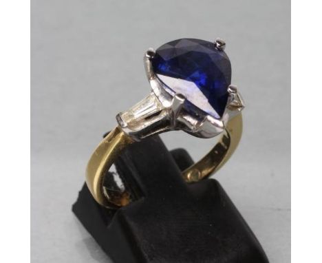 A SAPPHIRE DRESS RING, the pear cut stone claw set to shoulders each set with a shaped baguette cut diamond to a plain shank 