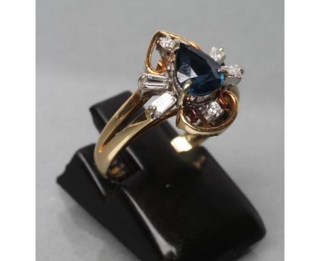 A SAPPHIRE AND DIAMOND DRESS RING, the tear cut sapphire claw set and flanked by two pairs of baguette cut diamonds and two s