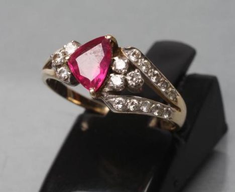 A RUBY AND DIAMOND RING, the triangular cut ruby claw set to diamond set asymmetric open shoulders and a plain unmarked shank