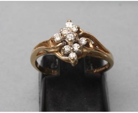 A DIAMOND CLUSTER RING, the nine small round brilliants claw set to twisted shoulders and a plain shank, stamped 14k, size J 