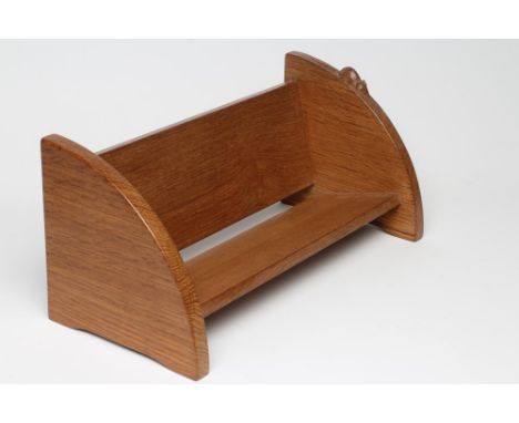 A ROBERT THOMPSON ADZED OAK BOOK TROUGH, of oblong form, the quadrant ends with bracket feet, carved mouse trademark in high 
