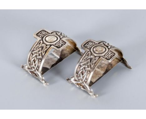 A PAIR OF EDWARDIAN NAPKIN RINGS, maker Liberty & Co., Glasgow 1911, of plain "D" form on dolphin head end supports, cast in 