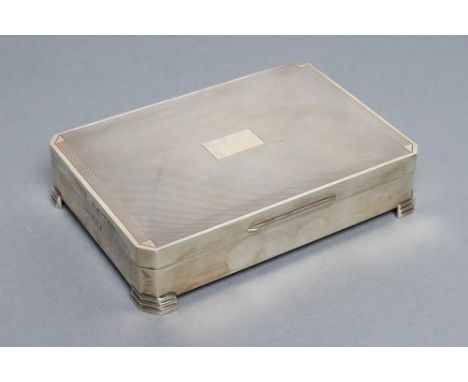 A CIGARETTE BOX, maker Harman Bros., Birmingham 1963, of plain canted oblong form raised upon four stepped angled bracket fee