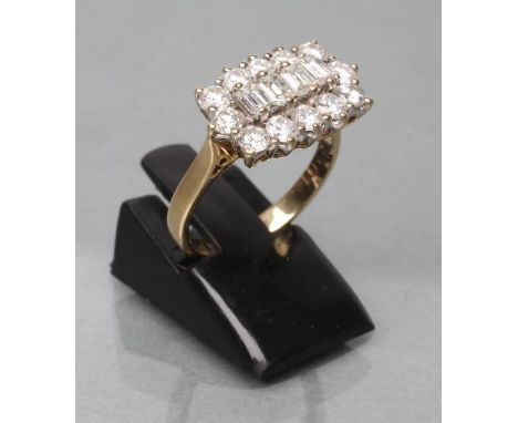 A DIAMOND DRESS RING, the four baguette cut central stones point set to a border of twelve brilliant cut stones to a plain 18