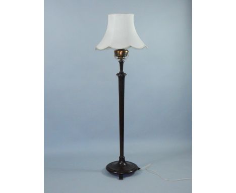 An oil standard lamp, early 20thC, converted to electricity, the brass lamp set above a turned oak column and outswept, circu