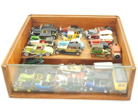 A display of vintage model cars, in a staged and glazed case.