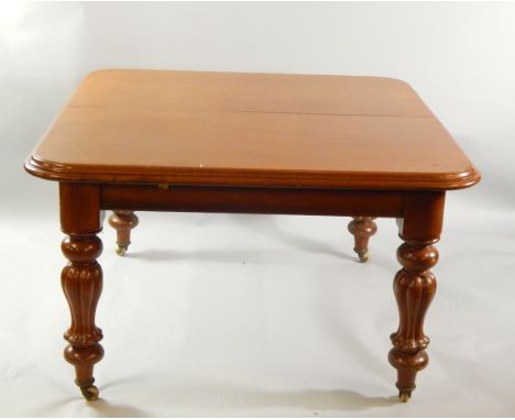 A Victorian mahogany wind out dining table, with baluster carved legs, brass capped on ceramic castors, 70cm high, 110cm wide