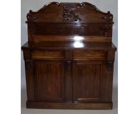 A Victorian mahogany chiffonier, The carved back with a single shelf, above two cushion drawers with cupboards below, raised 