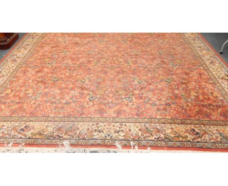 A Kashan wool rug, decorated with hunting scenes against a red ground, within a cream border, 275cm x 359cm.