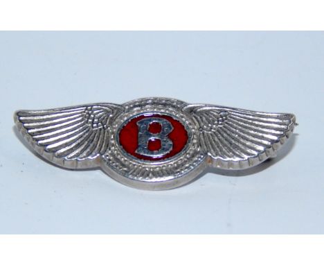 A silver Bentley pin badge, in the form of Bentley logo, with red enamel centre bearing letter B, 3.3cm wide. 