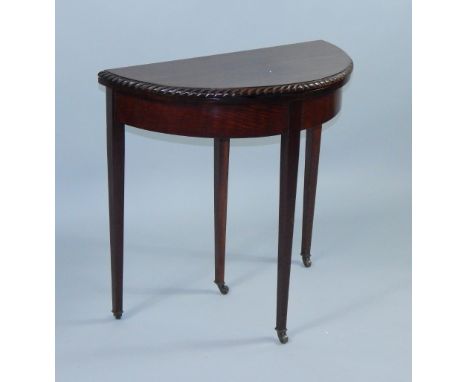 An Edwardian mahogany fold over card table, the demi lune top with spiral edge moulding, internal pull out drawer, raised on 