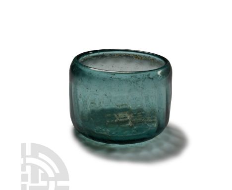 3rd-4th century A.D. or later. Thick-walled, cylindrical beaker with inwardly curved mouth, rolled rim; shallow dimples to ex