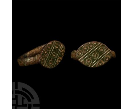 14th-15th century A.D. Featuring a rounded hoop supporting a lentoid bezel decorated with diagonal lines separating ring-and-