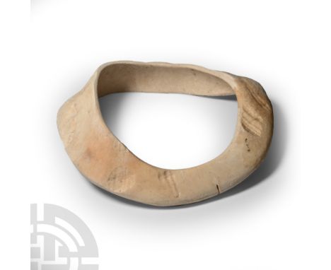 Neolithic, 4th-3rd millennium B.C. Annular panel cut from a large mollusc shell, domed in section.  107 grams, 12.2 cm (4 3/4