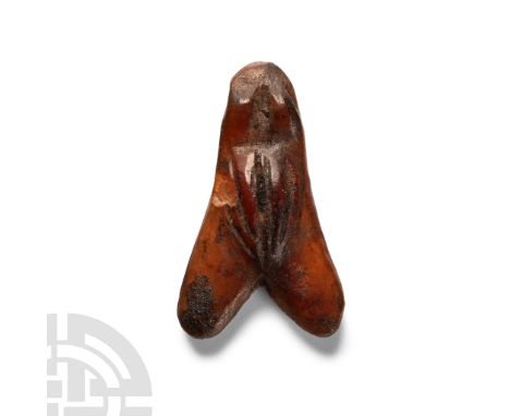 Late Period, 664-332 B.C. Carved with simple body and eye detailing and polished; drilled through the eyes for suspension. Cf