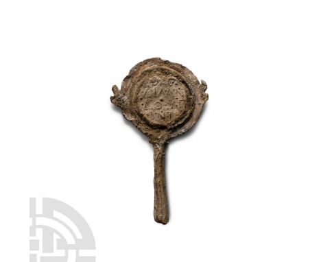 3rd century A.D. Comprising a discoid plate with running scroll border, lentoid-section handle with raised teardrop decoratio